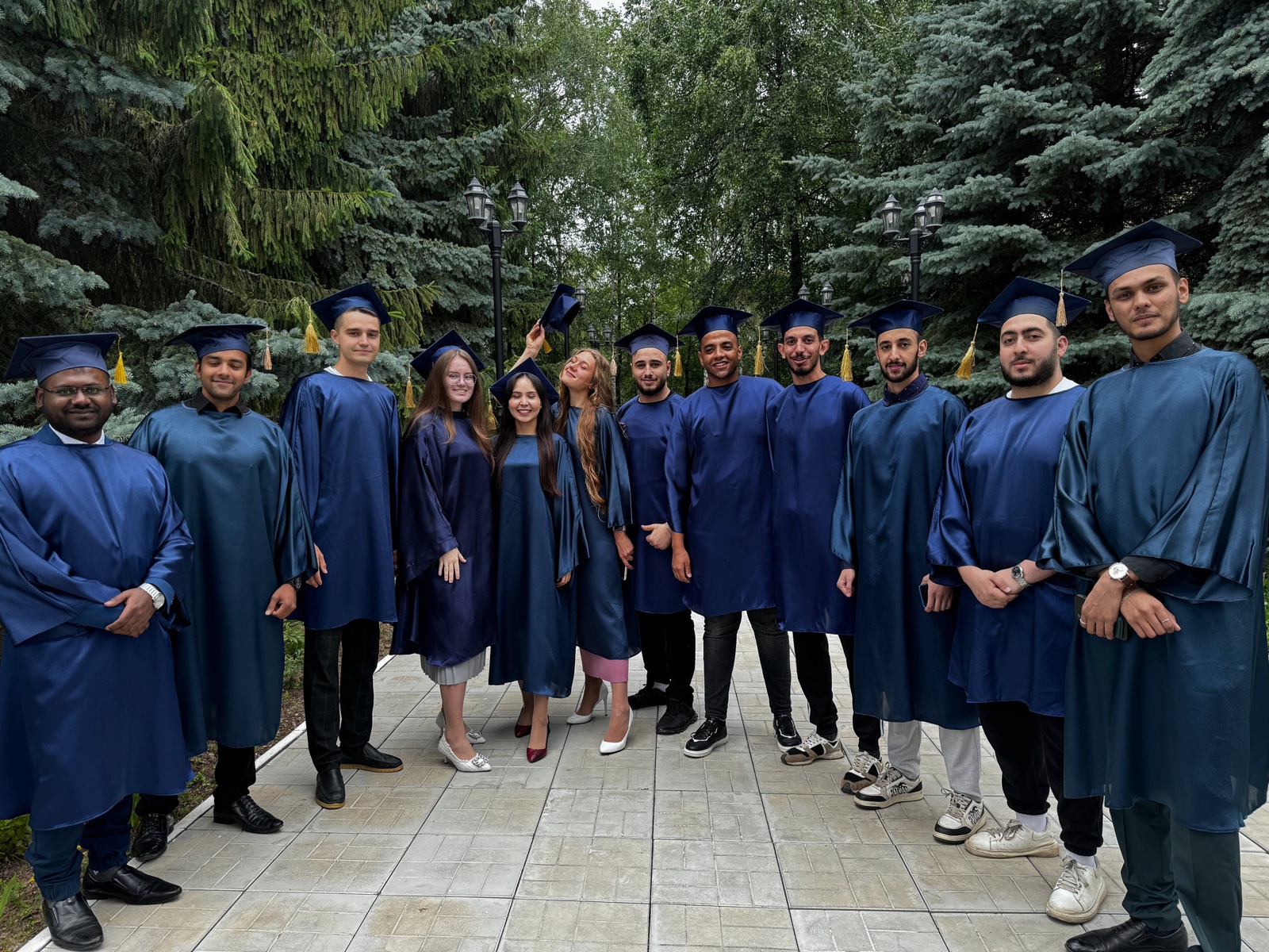 International graduating cohort in blue gowns and caps